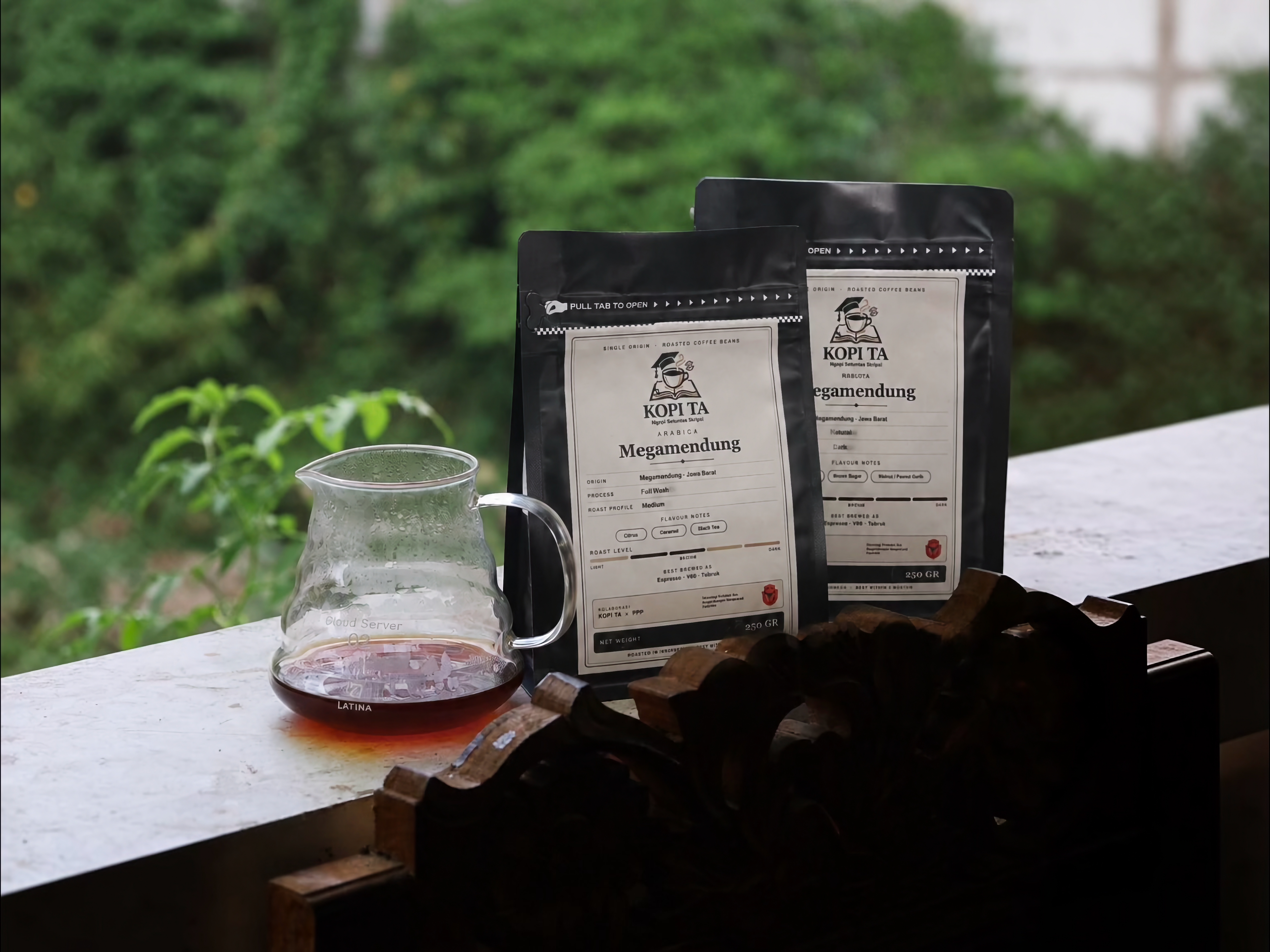 Produk kopi KOPI TA di meja dengan latar kebun